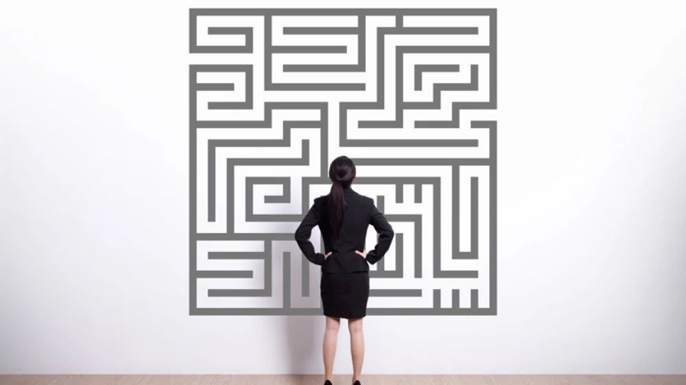 A person looking at a maze puzzle